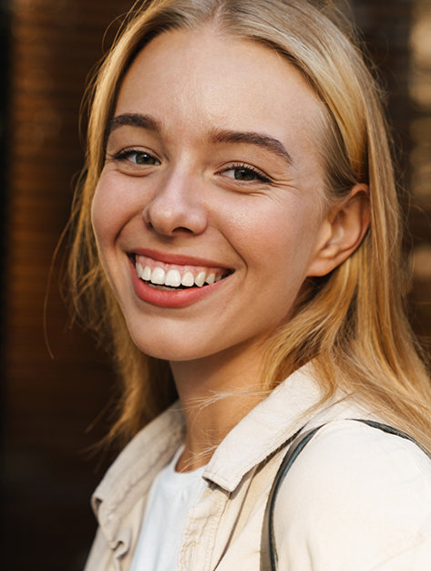 Blonde woman smiling after receiving cosmetic facial treatments in Houston