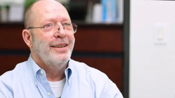 Older man with glasses giving testimonial