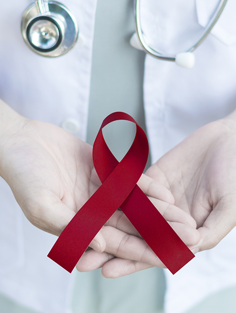 Doctor holding a red ribbon for oral cancer awareness