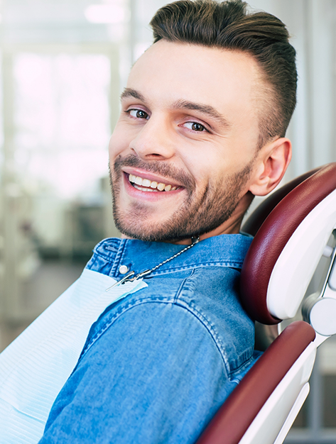 Man in the treatment chair grinning before his oral surgery
