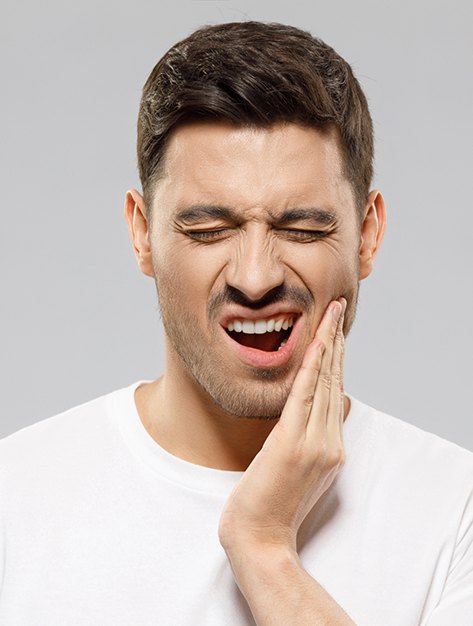Man holding the side of his jaw in pain before TMJ treatment in Houston