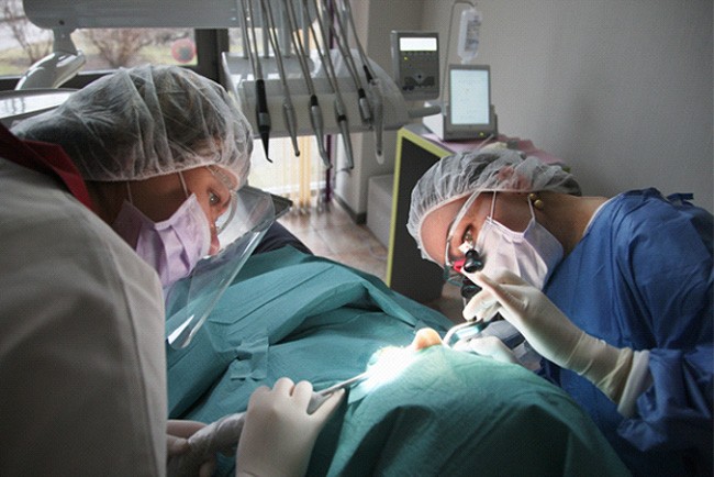 an oral surgeon operating on a patient