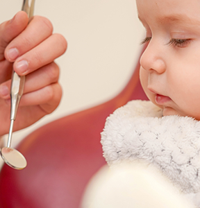 Dental mirror next to a baby's face