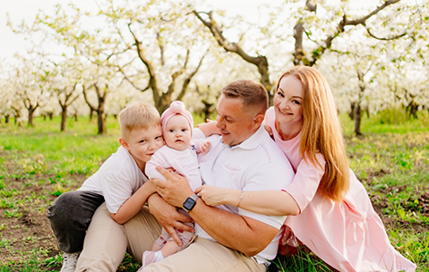 Family of four sitting on grass in a park