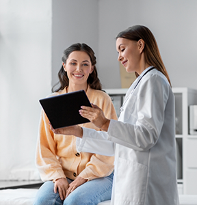 Doctor showing a tablet to a woman patient