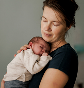 Mother holding her sleeping baby