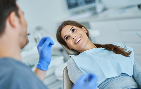 Woman in the treatment chair listening to her oral surgeon