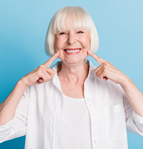 Senior woman pointing to her smile
