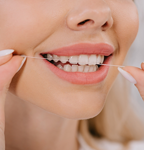 Close up of a person flossing their teeth