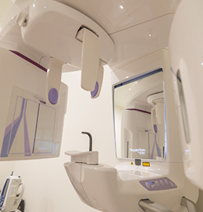 Cone beam CT scanning machine standing against a white wall