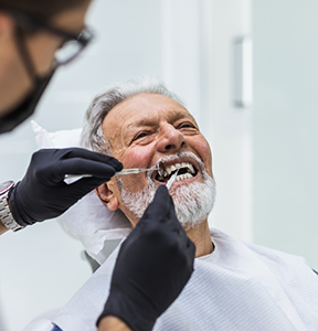 Senior man getting his teeth examined by his oral surgeon