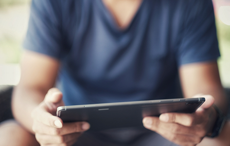 Person sitting down and holding a tablet
