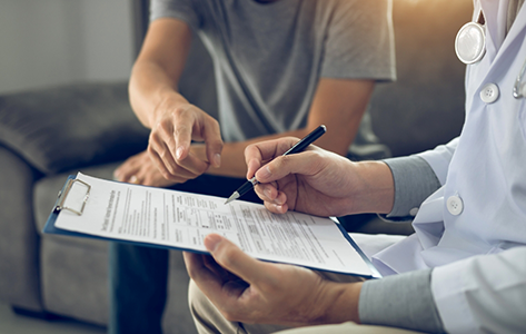 Patient and doctor looking at paperwork on a clipboard