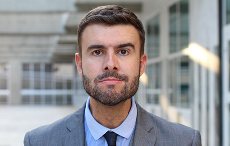 Man in a gray suit jacket and tie
