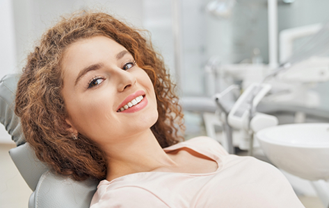 Smiling woman leaning back in the dental chair