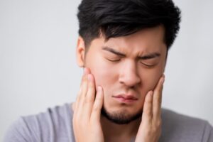 Frowning man experiencing wisdom tooth pain