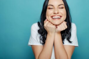 Happy woman holding her hands under her jaw