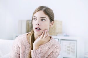 Woman with jaw pain touching the side of her face