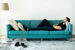 Man resting comfortably on sofa after oral surgery