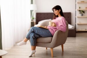 Woman reading a book while relaxing in a comfortable chair 